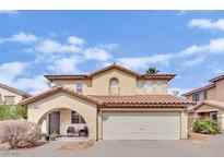 Two-story home featuring a red tile roof, arched entry, and a two-car garage against a sunny sky at , Las Vegas, NV 89139