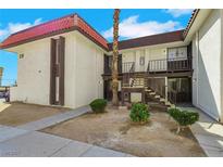 Two story condo building shows off a red tile roof and a desert landscape in a gated community at 1405 Vegas Valley Dr # 312, Las Vegas, NV 89169