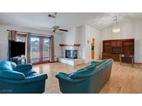 Spacious living room boasts a cozy fireplace, wood floors, and ample natural light from sliding glass doors at 2820 Golf Links Dr, Las Vegas, NV 89134