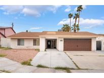 Charming single-story home featuring a two-car garage, desert landscaping, and palm trees at 3994 Ridgewood Ave, Las Vegas, NV 89120