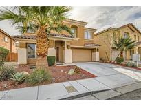 Two-story home with a desert landscape, two car garage and a covered front porch and mature palm tree at 6655 Little Owl Pl, North Las Vegas, NV 89084