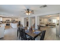 Open floor plan showcasing the kitchen and dining area with a ceiling fan and modern decor at 6924 Ghost Ranch Ave, Las Vegas, NV 89179