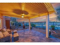 Comfortable back patio area complete with desert landscaping, overhead light, and wrought iron fence with a view at 10633 Tinta Ln, Las Vegas, NV 89144