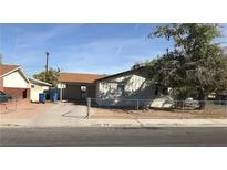 A single-story home with a driveway, carport, desert landscaping, and chain-link fence at 3258 Glenhurst Dr, Las Vegas, NV 89121