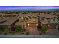 Stunning two-story home with a brick-accented facade, lush landscaping, and a brick driveway at 342 Molinetto St, Las Vegas, NV 89138