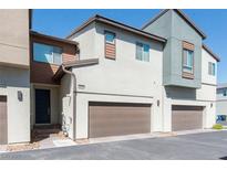 Modern townhome exterior with private garage and neutral color scheme on a sunny day at 6145 May River St, Las Vegas, NV 89148