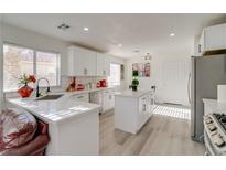 Bright kitchen features white cabinets, subway tile backsplash, and a center island with quartz countertop at 1100 Meridian Bay Dr, Las Vegas, NV 89128