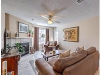 Comfortable living room with a fireplace, ceiling fan, and plush brown leather furniture at 1375 E Hacienda Ave # 114, Las Vegas, NV 89119
