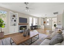 Bright living room featuring a fireplace, built in shelving, ceiling fan and ample natural light at 2292 Cassatt Dr, Henderson, NV 89074