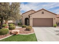 Charming single-story home featuring a well-manicured lawn, desert landscaping and a two-car garage at 2388 Aztec Ruin Way, Henderson, NV 89044