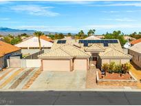 Inviting single-story home with a desert landscape, solar panels, and a three-car garage at 7033 Red Tide Dr, Las Vegas, NV 89131
