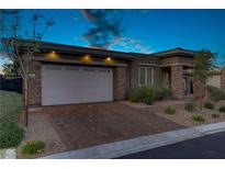 Charming single-story home featuring stone accents, a two-car garage, and desert landscaping at 8 Reflection Cove Dr, Henderson, NV 89011