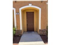 Inviting front door with a charming arched entrance and stylish stacked stone accents at 9303 Gilcrease Ave # 1097, Las Vegas, NV 89149
