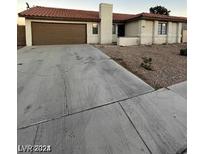 Charming single-story home features a two-car garage, low-maintenance landscaping, and a red tile roof at 1617 Joshua Tree Ct, Las Vegas, NV 89108