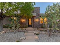 Charming home with a stone facade, desert landscaping, and a decorative iron front door at 48 Panorama Crest Ave, Las Vegas, NV 89135