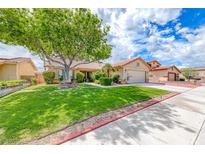 Charming single-story home with lush green lawn, mature tree, and well-maintained landscaping in a quiet neighborhood at 7533 Grenfell Dr, Las Vegas, NV 89129