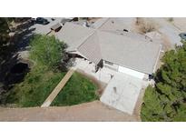 Aerial view of a home with a spacious driveway, mature trees, and a well-maintained lawn at 1540 Labrador St, Pahrump, NV 89048