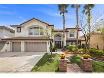 Stunning two-story home featuring a three-car garage, lush landscaping, and a welcoming entrance at 2445 Ping Dr, Henderson, NV 89074