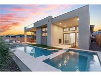 Stunning modern home showcasing a luxurious pool with integrated spa and a spacious outdoor living area at dusk at 144 Tre Pietre St, Henderson, NV 89011
