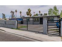 Charming home featuring a modern metal gate, gray exterior paint and beautiful desert landscaping with a blue sky backdrop at 244 N 19Th St, Las Vegas, NV 89101