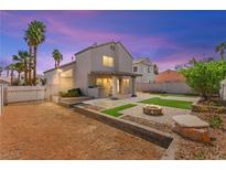 Spacious backyard features manicured landscaping, a cozy fire pit, and a covered patio area, perfect for outdoor entertaining at 3033 Brigantine Way, Las Vegas, NV 89128