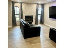 Contemporary living room boasts stone fireplace, hardwood floors, and plenty of natural light at 4083 Nook Way # A, Las Vegas, NV 89103