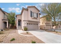 Two-story home with attached two car garage and low maintenance desert landscaping in front at 7013 Pacific Coast St, Las Vegas, NV 89148
