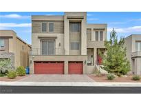 Modern two-story home boasts a red two-car garage, balcony, and contemporary design at 9830 Wild Coyote Ct, Las Vegas, NV 89141