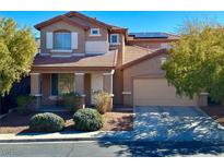 Two-story home featuring desert landscaping, attached two-car garage, and solar panels on roof at 1011 Pecos River Ave, Henderson, NV 89002