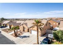 Single-story home with desert landscaping, tile roof, three-car garage, and driveway with desert views at 209 Eucalyptus Ln, Mesquite, NV 89027