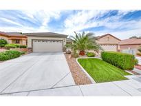 Charming single story home featuring a spacious driveway and well manicured desert landscaping at 2561 Cosmic Dust St, Henderson, NV 89044