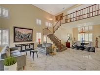 Bright living room with marble floors, a staircase, and modern decor creates an inviting space at 7613 Hackensack Ct, Las Vegas, NV 89128