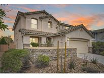 Charming two-story home with a two-car garage, landscaped yard, and decorative stone wall at 10808 Wallflower Ave, Las Vegas, NV 89135