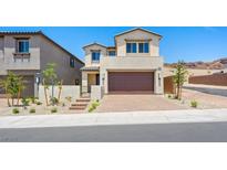 Inviting two-story home with a paver driveway, desert landscaping, and a neutral color scheme at 74 Via Montoro, Henderson, NV 89011