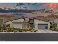 Contemporary home with desert landscaping, blue door and mountains in background at dusk at 10271 Meridian Hill Ave, Las Vegas, NV 89135