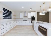 Bright kitchen features marble countertops, stainless steel appliances and modern white cabinetry at 10631 Sariah Skye Ave, Las Vegas, NV 89166