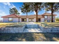 Charming single-story home with a red tile roof, large windows, and mature trees enhancing its curb appeal at 1967 N Moapa Valley Blvd, Logandale, NV 89021