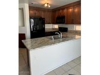 Well-lit kitchen showcasing granite countertops, stainless steel sink, and updated appliances at 2211 Arborwood Way, Las Vegas, NV 89142