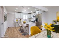 Bright kitchen featuring white cabinets, stainless steel appliances, an island with seating, and modern decor at 2621 Bello Dr, North Las Vegas, NV 89030