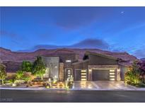 Stunning modern home exterior with a well-manicured yard and mountain backdrop at twilight at 6103 Stone Rise St, Las Vegas, NV 89135