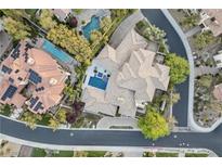 Stunning aerial view of a luxurious home with multiple pools and lush landscaping in an upscale neighborhood at 9 Greely Club Trl, Henderson, NV 89052