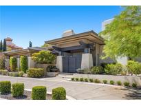 Contemporary home featuring a gated entrance with manicured landscaping and a paved driveway under a blue sky at 9 Greely Club Trl, Henderson, NV 89052
