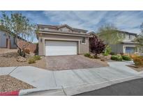 Charming two-story home featuring a brick driveway, manicured landscaping, and a two-car garage at 9370 Burning Sage Ave, Las Vegas, NV 89149
