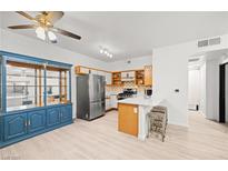 Bright eat-in kitchen features a breakfast bar, stainless steel refrigerator, and blue china cabinet at 5751 Hacienda Ave # 135, Las Vegas, NV 89122
