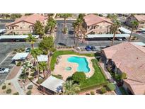 Aerial view of community pool and spa surrounded by lush landscaping, multiple seating areas, and manicured lawn at 5751 Hacienda Ave # 135, Las Vegas, NV 89122