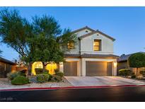 Charming two-story home with a two-car garage and meticulously landscaped front yard at dusk at 7416 Redhead Dr, North Las Vegas, NV 89084