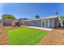 Private backyard with a patch of grass, concrete patio, storage shed, and desert landscaping at 6770 Laronda Ln, Las Vegas, NV 89156