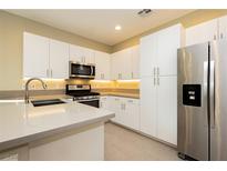 Bright kitchen features modern white cabinetry, stainless steel appliances, and sleek countertops at 11236 Rainbow Peak Ave # 210, Las Vegas, NV 89135