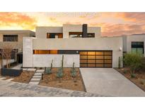 Modern home with a sleek design, desert landscaping, and eye-catching golden garage door at 12 Falling Canyon Ct, Henderson, NV 89011