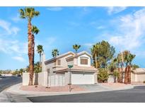Charming two-story home featuring a tile roof, an attached garage, and well-manicured landscaping with mature palm trees at 125 Firecreek Cir, Las Vegas, NV 89107